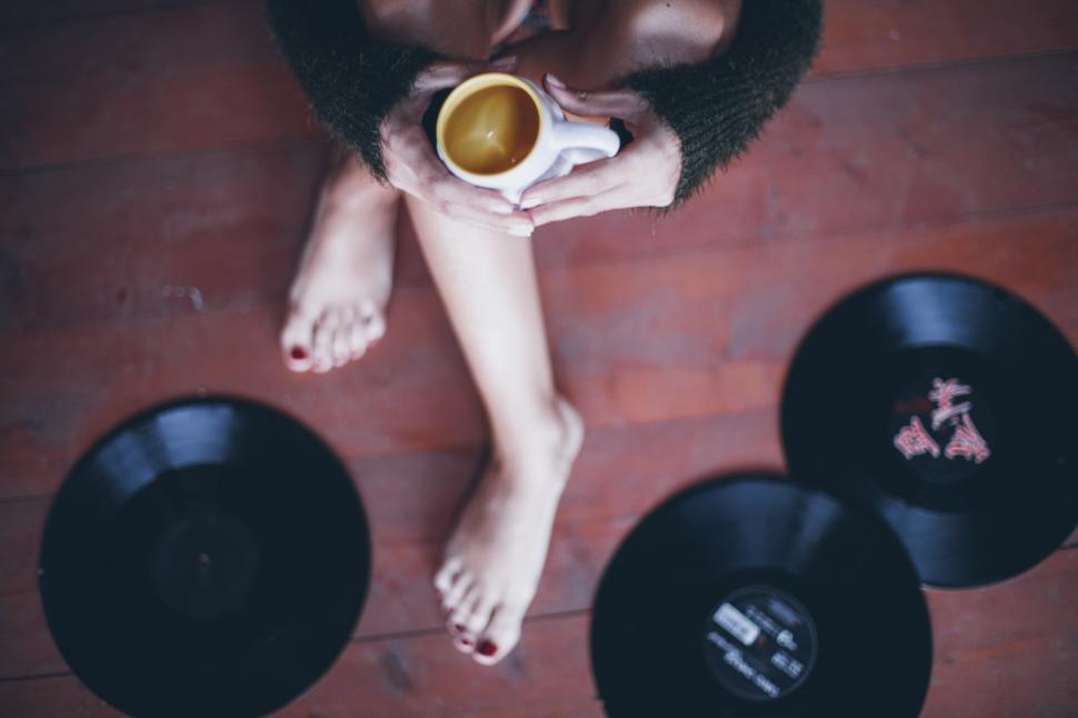 Free Image of Overhead view of a woman\'s hands holding a cup of coffee 